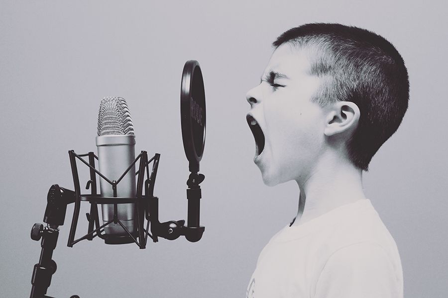boy yelling persuasive words into microphone