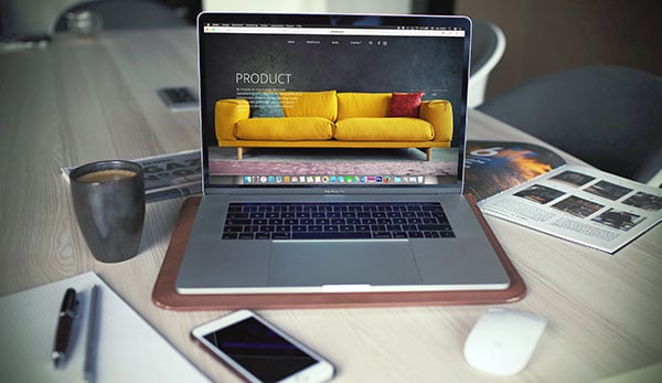 Macbook laptop with responsive website on desk