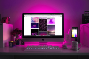 Computer at desk with pink lighting